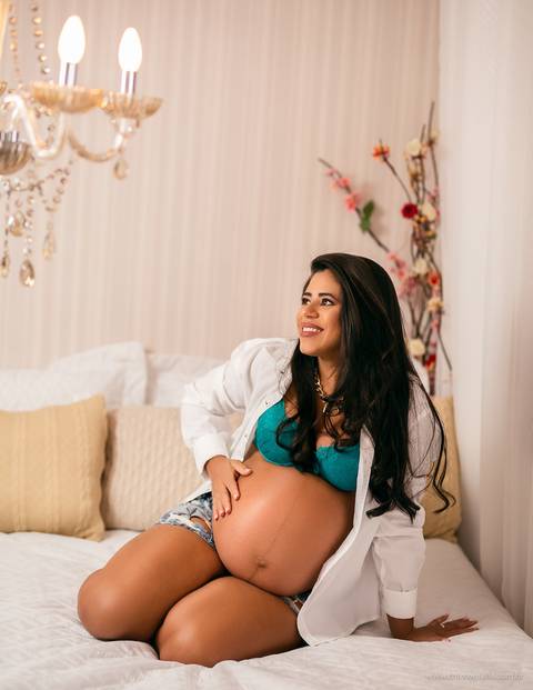 Gestante sentada na cama '
