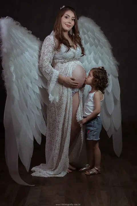 Ensaio de gestante com asas de anjo e filho'