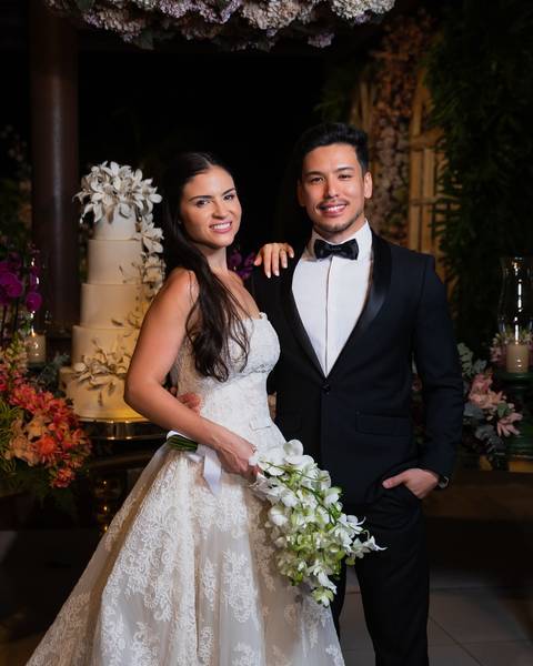 Noivos na mesa do bolo posando para foto tradicional em casamento'