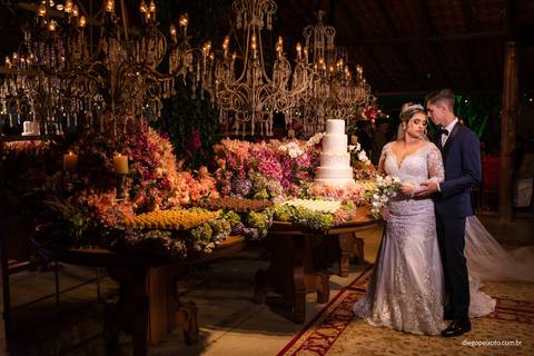 fotografia de noivos na mesa do bolo'