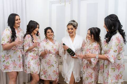 noiva e madrinhas estourando champagne'