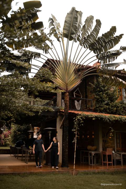 A chuva intensifica o romantismo enquanto Débora e Diego se abraçam diante da majestosa paisagem da Fazenda Cachoeira. Um momento mágico capturado para eternizar o amor.'