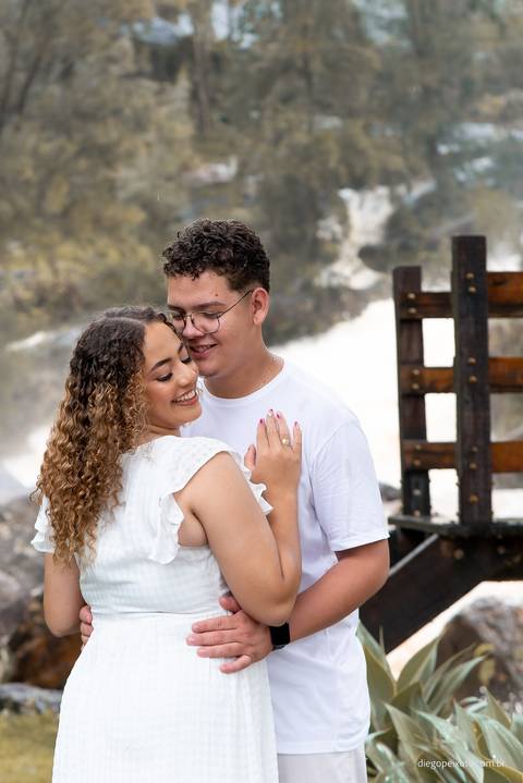 Os olhos brilhantes de Débora revelam a felicidade genuína enquanto ela e Diego exploram os jardins da Fazenda Cachoeira. Uma captura encantadora de um momento de descontração.'