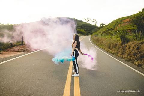 ensaio de 15 anos com fumaça colorida no meio de uma via'