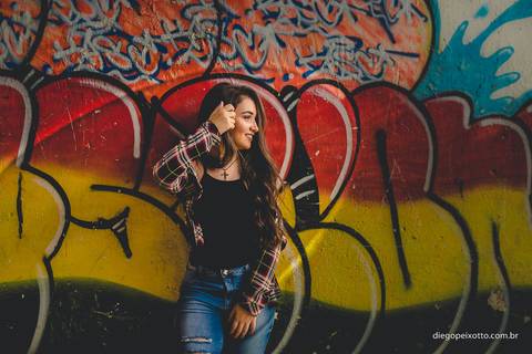 muito estilo em um ensaio de quinze anos realizado debaixo de um viaduto no centro de uma cidade num muro grafitado'