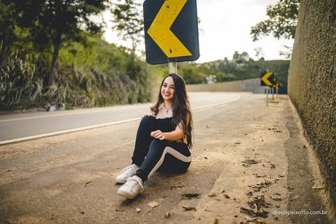 ensaio fotográfico urbano de uma menina ao lado de uma placa de sinalização de trânsito'