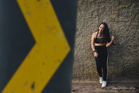 garota estilosa posa para foto durante um ensaio fotografico urbano realizado no meio de uma via'