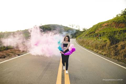 no meio de uma via garota faz foto incrivelmente linda com fumaça colorida'