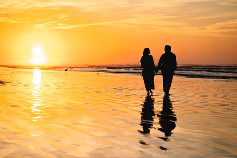  Bruna e Antonio caminhando pela areia de Iguape, em uma cena leve e natural que transmite sintonia e tranquilidade.'