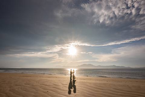 O pôr do sol em Cananéia iluminando o casal com tons quentes, encerrando o ensaio pré‑wedding com uma luz perfeita e cheia de significado.'