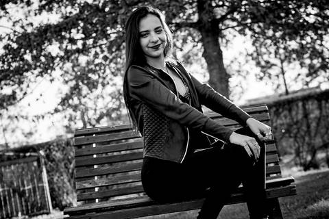 chica sentada en banco de plaza 15 años'