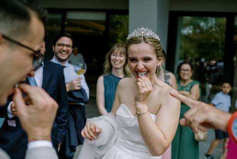 Momento divertido no casamento, com a noiva a sorrir enquanto brinca com os convidados, transmitindo alegria e descontração, casamento descontraído, alegria, momentos únicos, fotografia de casamento, quinta dos jasmins'