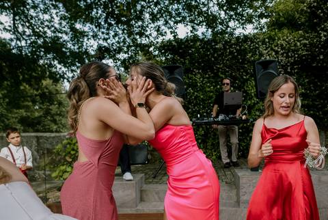 Duas convidadas num momento de diversão e cumplicidade durante o casamento, ao som de música ambiente com DJ ao fundo. Uma celebração repleta de emoção e alegria. casamento, diversão, DJ, momentos únicos, convidados felizes, celebração.'