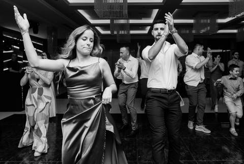 Convidados a dançar durante uma animada festa de casamento. O ambiente de celebração reflete a alegria e a diversão do momento.  dança no casamento, convidados animados, festa de casamento, celebração, fotografia de eventos, momentos especial. '