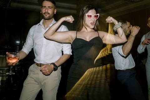 Convidados divertidos a celebrar numa festa de casamento, com poses descontraídas e expressões animadas. O ambiente reflete alegria e descontração. festa de casamento, celebração animada, convidados felizes, fotografia de eventos, momentos únicos. '