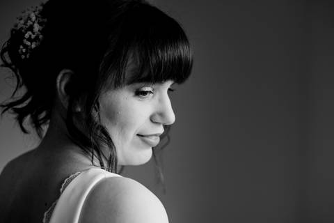 Retrato intimista de noiva em preto e branco, destacando penteado com flores e maquilhagem delicada. Elegância e emoção capturadas antes da cerimónia. noiva, retrato de casamento, penteado com flores, fotografia de casamento, Portugal.'