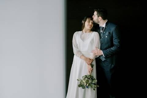 Noivos em momento íntimo e romântico, com o noivo a dar um beijo carinhoso na testa da noiva. Fotografia elegante e minimalista, perfeita para eternizar o amor. fotografia de casamento, noivos apaixonados, amor verdadeiro, casamento em Portugal.'