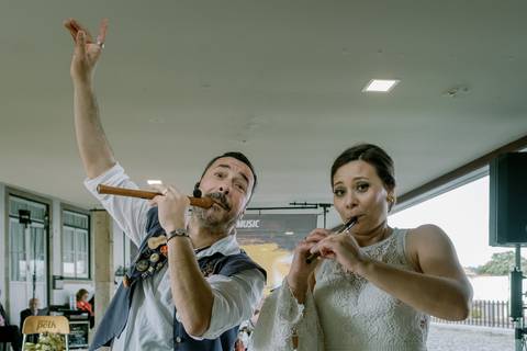 Noiva a tocar flauta irlandesa ao lado de músico profissional durante celebração do seu casamento. Um momento único de diversão e autenticidade. casamento original, música irlandesa, fotógrafo de casamentos, fotografia de casamentos.'