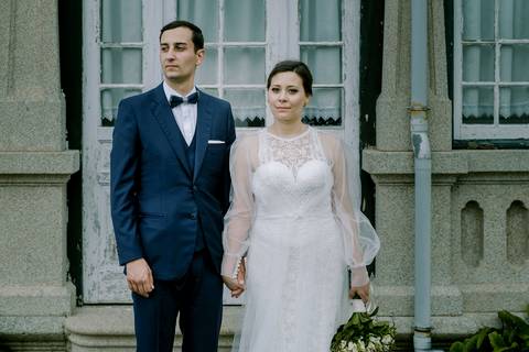 Noivos lado a lado num cenário rústico, com um fundo de janelas antigas e arquitetura clássica. Elegância e simplicidade. fotografia de casamento, fotógrafo em Portugal, sessão de noivos, quinta de Santiago'