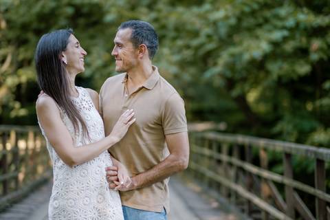Casal sorridente em ponte de madeira durante sessão fotográfica de namoro em ambiente natural. Fotógrafo profissional de Cantanhede capta momentos autênticos e espontâneos.
 sessão de casal, fotografia de namoro, fotos românticas'