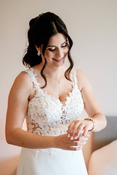 O sorriso espontâneo ao vestir o vestido de noiva. A Rui Costa Freire Photography capta a vibração e a elegância deste momento criando uma narrativa visual sofisticada e intemporal do casamento. vestido de noiva com renda, preparativos da noiva momento'