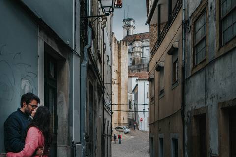 namorados beijam-se com a torre da universidade de coimbra por trás'