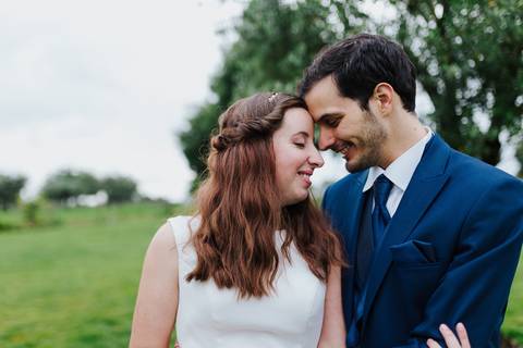 Fotografia de casamento ao ar livre com noivos abraçados. Noiva em vestido branco e noivo em fato azul. fotógrafo de casamento na quinta das janelas em Coimbra num casamento civil'