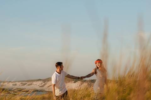Casal de namorados em sessão de solteirosao pôr do sol, caminhando de mãos dadas pelas dunas. ambiente natural sessão de casal, pôr do sol, fotógrafo de casamento , praia da tocha'