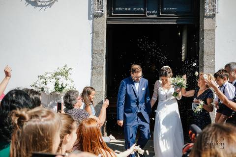 saída dos noivos da igreja debaixo de chuva de arroz'
