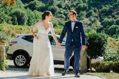 noivos de mãos dadas e a sorrir a entrar na quinta'