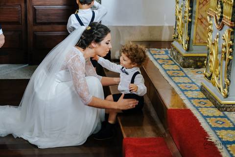 noiva prepara-se para abraçar o filho depois do padre a casar'