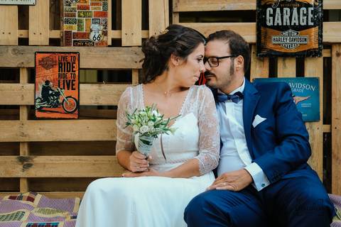 noivos sentados em banco feito de fardos de palha'