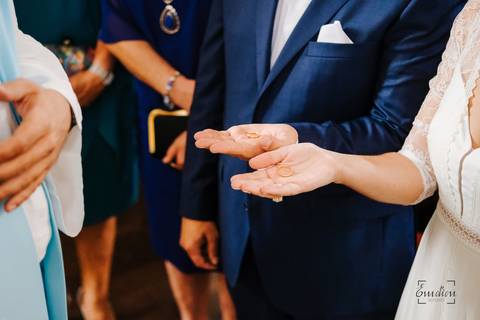 noivos seguram as alianças na mão'