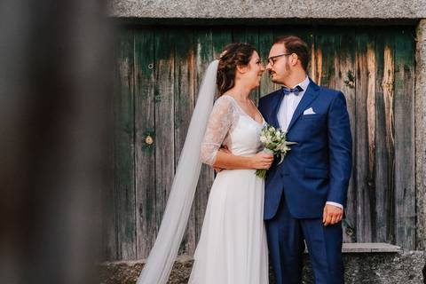 noivos preparam-se para se beijarem junto a portão de madeira na quinta da torre'