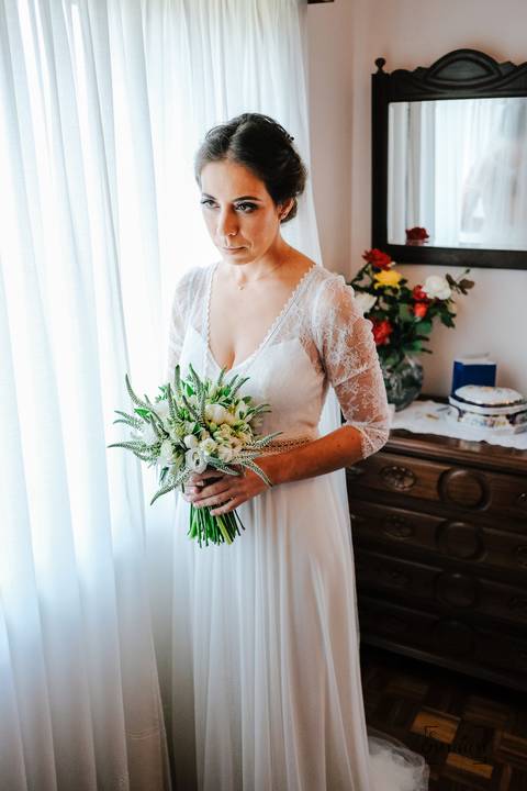 noiva pega no bouquet e olha para ele'