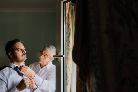 pai do noivo ajeita a gravata do noivo'