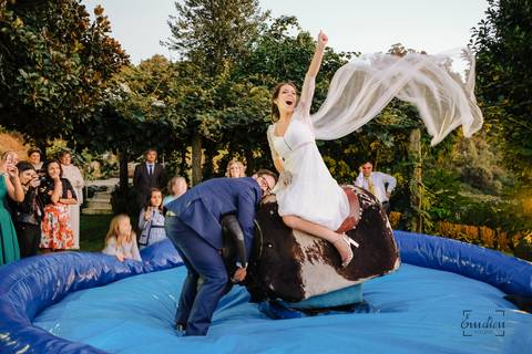 noiva anda de touro mecânico enquanto o noivo segura no cornos do toiro na quinta da torre'