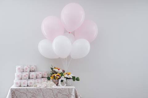 mesa com as lembranças do baptizado e balões'