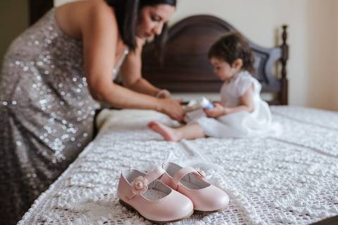 madrinha veste a criança no dia do baptizado'