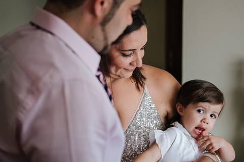 padrinhos seguram a criança ao colo'