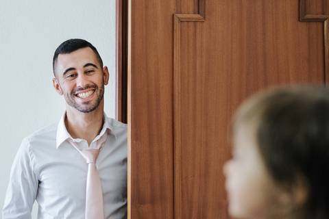 pai sorri para a criança no dia do baptismo'