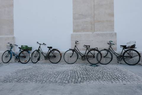 várias bicicletas encostadas à parede da igreja de cantanhede'
