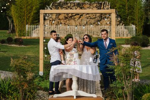 pais e padrinhos brindam depois de cortarem o bolo do baptizado'