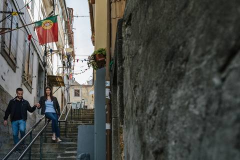 namorado pega na mão da namorada enquanto ela escorrega no corrimão das escadas'