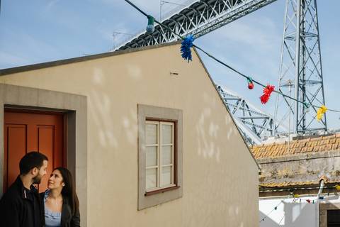 casal de namorados beija-se com a ponte d. luís por trás'