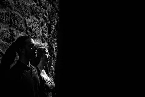 namorados encostados a parede a receber luz do sol na cidade do porto'