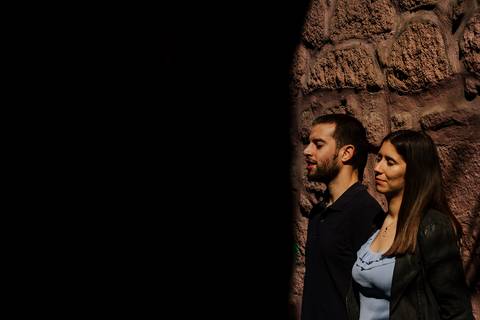 namorados encostados a parede a receber luz do sol na cidade do porto'