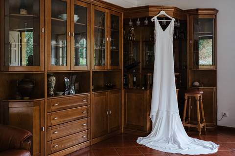 Vestido da noiva pendurado na garrafeira da sala'