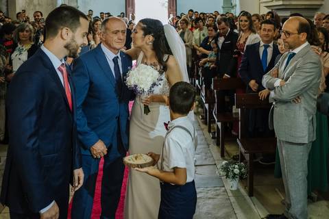 Noiva beija o pai ao chegar ao altar da igreja de Portunhos'