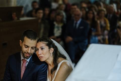 Noiva chora no ombro do noivo durante a cerimónia de casamento'